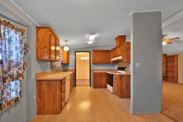 a kitchen with stainless steel appliances granite countertop a sink and a refrigerator
