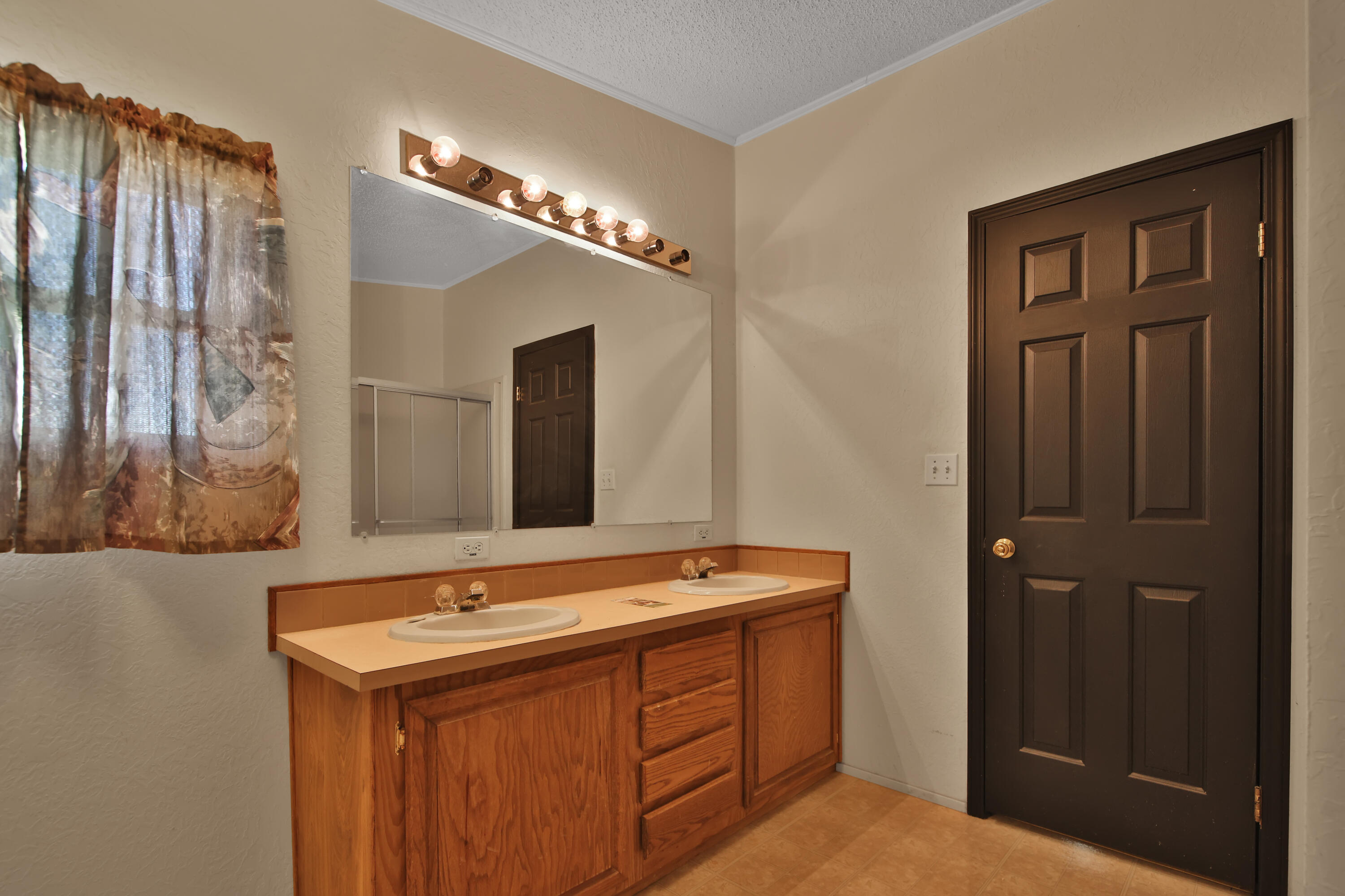 120 Highway 114 Estates Road Lubbock, TX 79407 - Photo 24 of 49 a bathroom with a sink a mirror and a shower