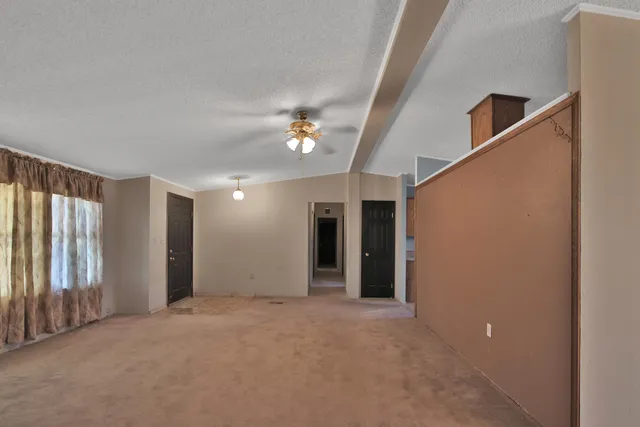 an empty room with a fireplace and a ceiling fan