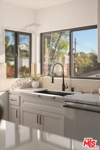 a kitchen with a sink stove top oven and cabinets