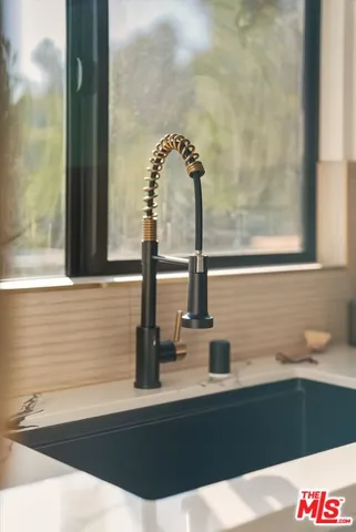 a kitchen with stainless steel appliances a stove a sink and a dining table with chairs