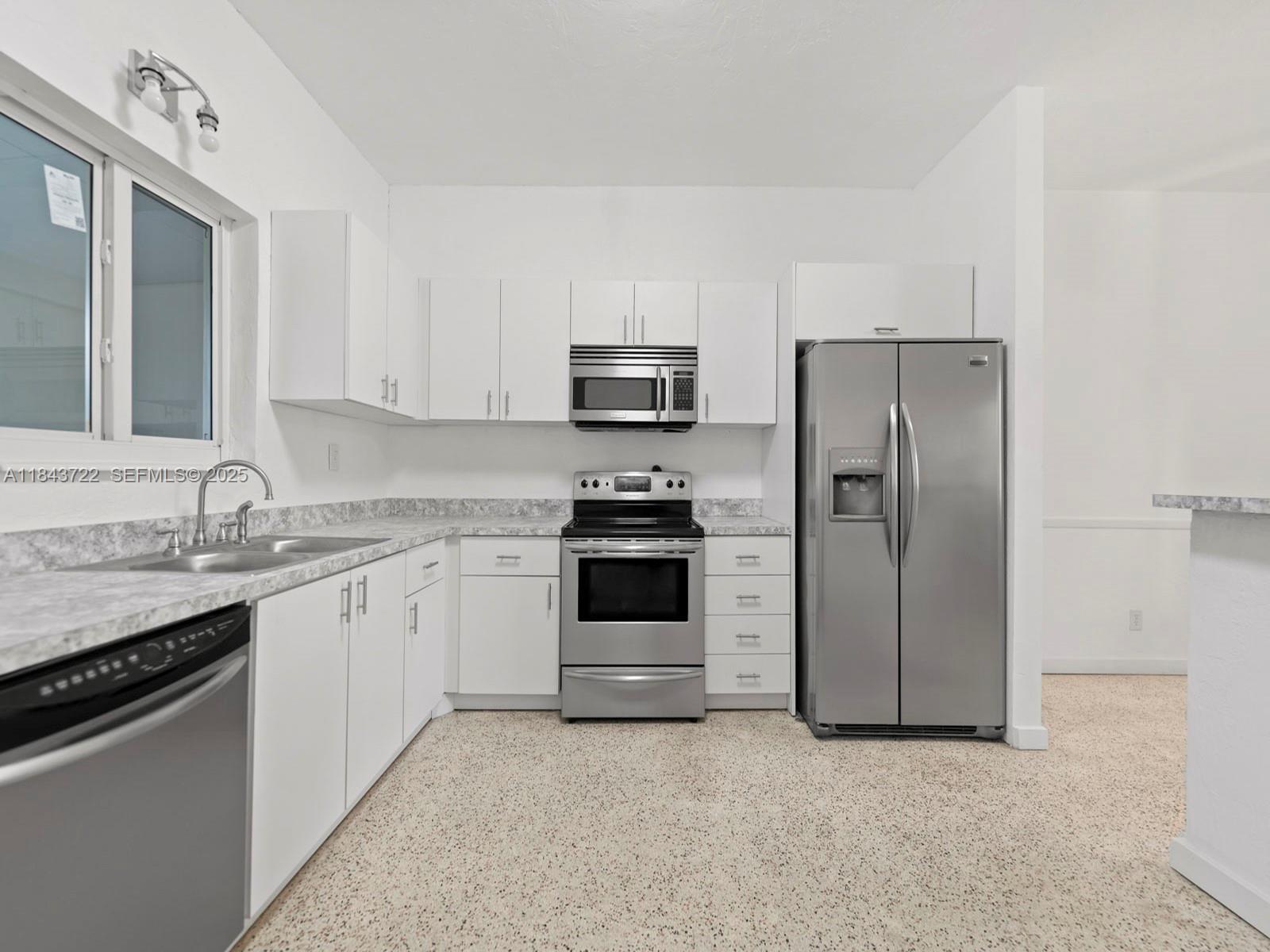 17300 Southwest 300th Street Homestead, FL 33030 - Photo 6 of 33 a kitchen with granite countertop a refrigerator stove and sink