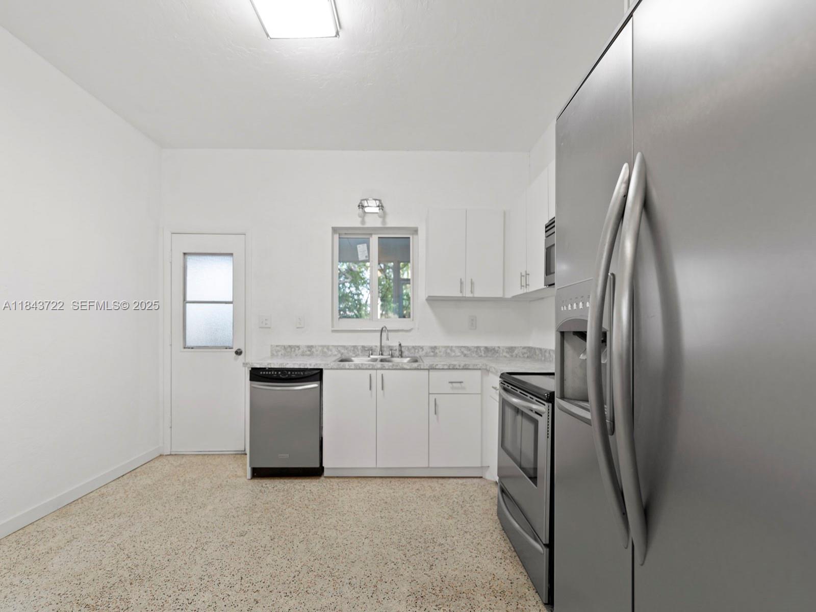17300 Southwest 300th Street Homestead, FL 33030 - Photo 9 of 33 a kitchen with cabinets and stainless steel appliances