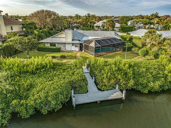 an aerial view of a house with a garden and lake view