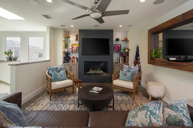 a living room with furniture a flat screen tv and a fireplace