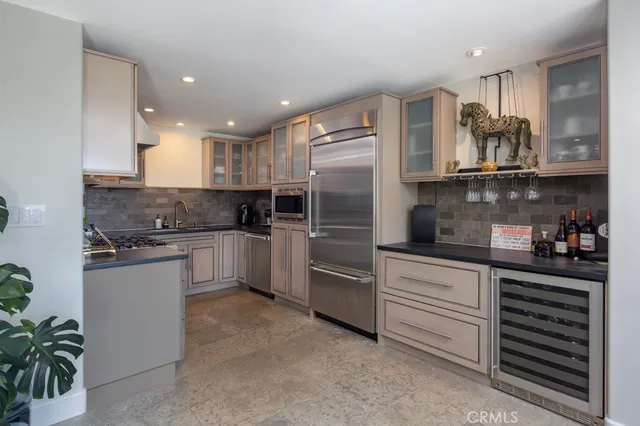 a kitchen with stainless steel appliances granite countertop a refrigerator sink and cabinets