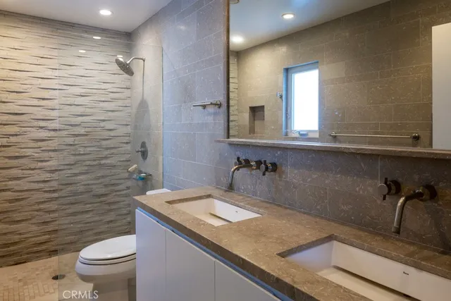 a bathroom with a granite countertop sink a toilet and a mirror