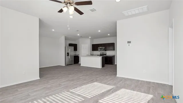 a view of a kitchen with a sink and dishwasher a refrigerator with wooden floor