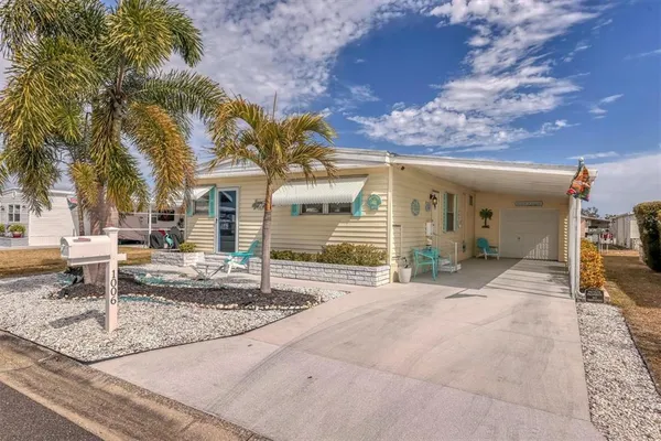 a front view of a house with a yard and potted plants