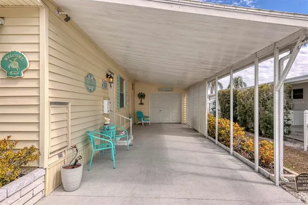 a porch with a table and chairs and potted plants