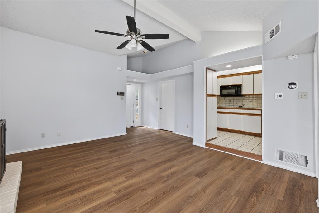 18040 Midway Road, Unit 195 Dallas, TX 75287 - Photo 6 of 17 a view of a kitchen with wooden floor and a ceiling fan