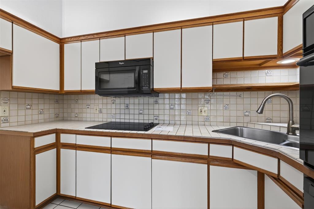 18040 Midway Road, Unit 195 Dallas, TX 75287 - Photo 9 of 17 a kitchen with a sink cabinets and a window