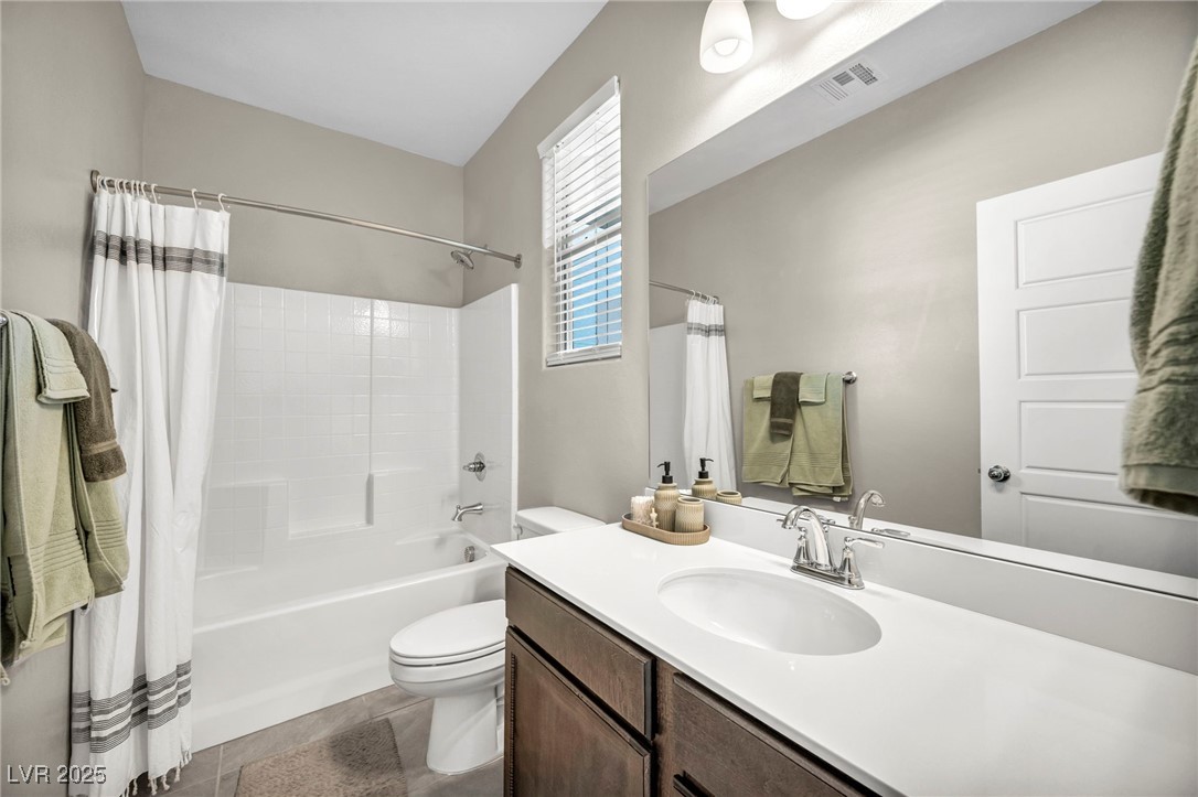 1012 East Sunset Road Henderson, NV 89011 - Photo 36 of 77 Bathroom featuring shower / bath combo with shower curtain, vanity, and dark tile patterned floors