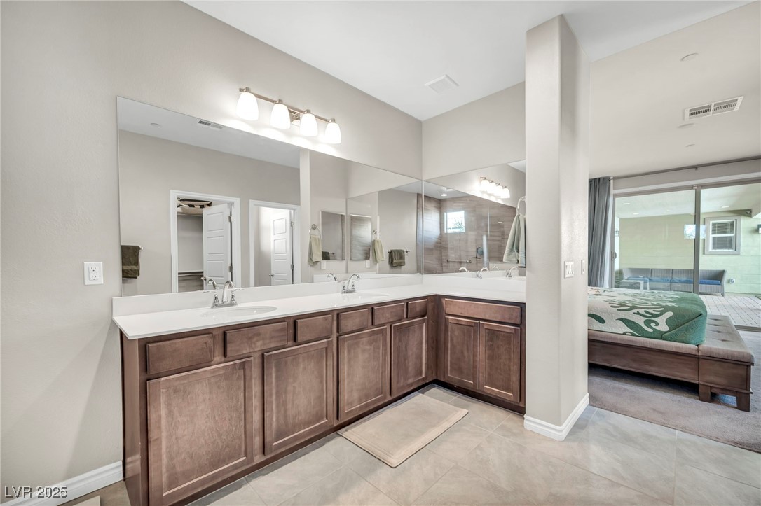 1012 East Sunset Road Henderson, NV 89011 - Photo 59 of 77 Ensuite bathroom featuring double vanity and light tile patterned floors