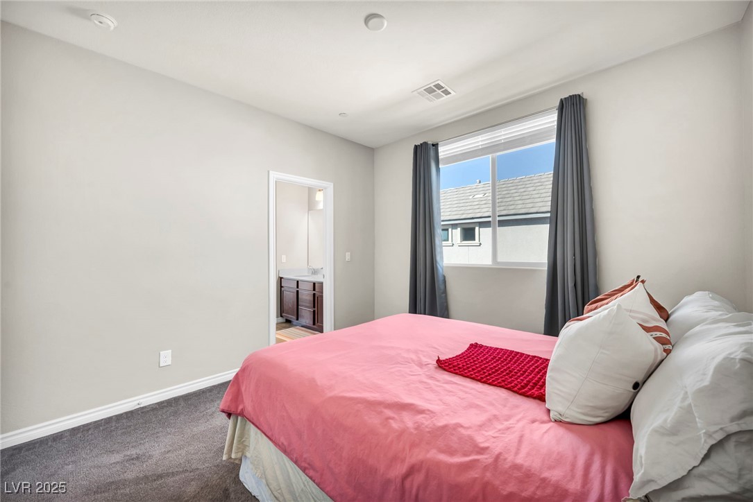1012 East Sunset Road Henderson, NV 89011 - Photo 65 of 77 Carpeted bedroom with ensuite bath and baseboards