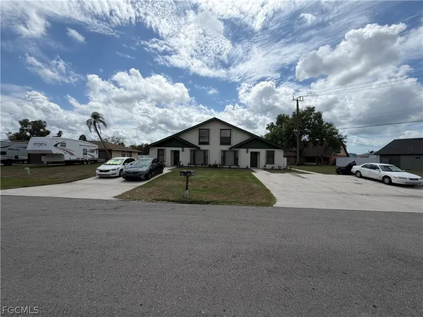 a view of a house with a yard and sitting area