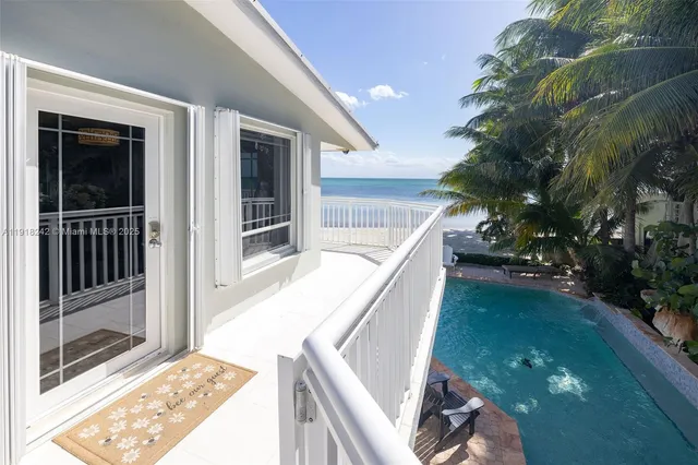 a living room with furniture kitchen view and a chandelier