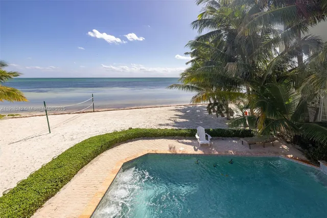 a bedroom with a bed a large window and wooden floor