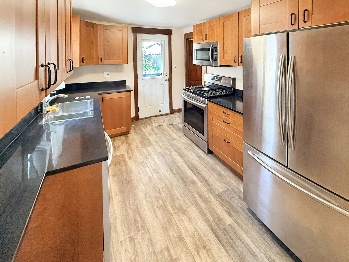 511 Chestnut Street Waukegan, IL 60085 - Photo 7 of 17 a kitchen with stainless steel appliances a refrigerator sink and stove