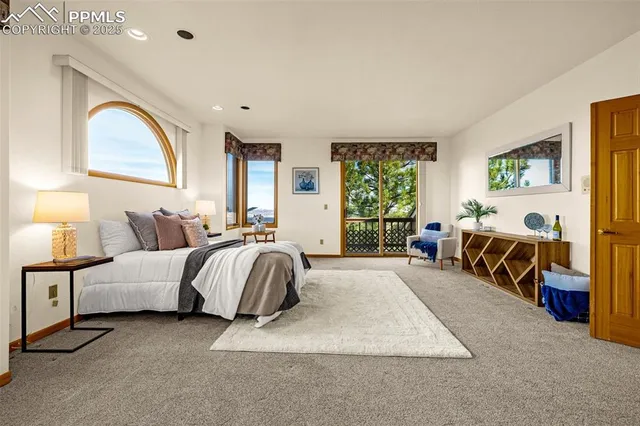 a spacious bedroom with a bed a table and a large window