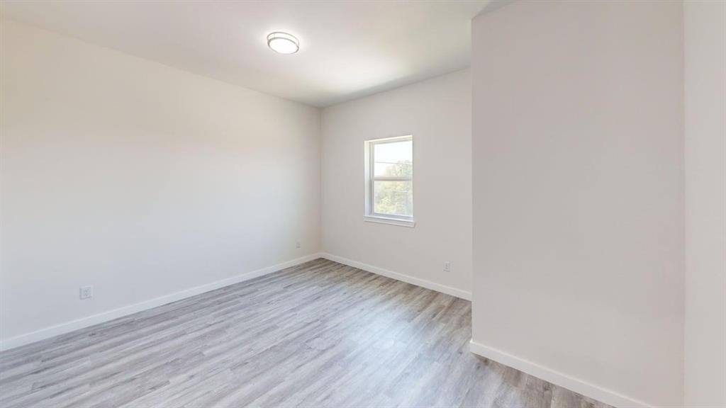 6702 South Lancaster Road Dallas, TX 75241 - Photo 13 of 20 Neutral wall paint, wood-finish flooring, recessed lighting, and a single window