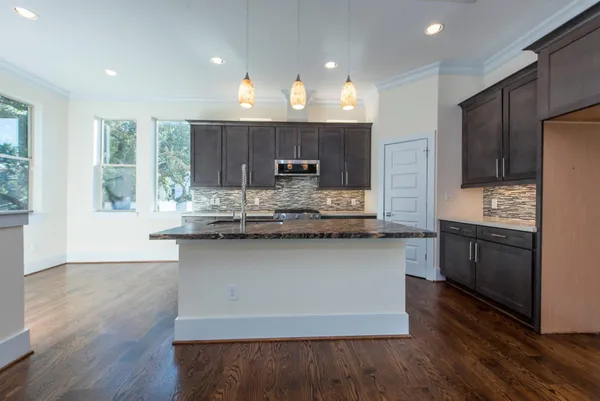 a kitchen with stainless steel appliances granite countertop a sink a stove a refrigerator and cabinets