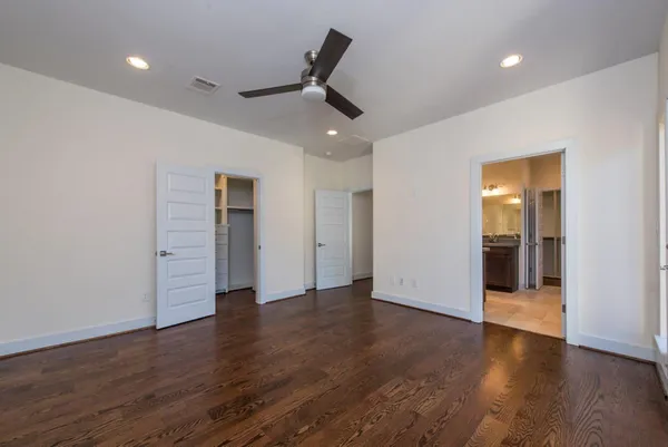 an empty room with wooden floor and natural light
