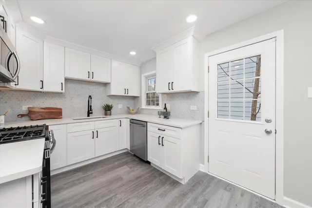 a kitchen with granite countertop white cabinets and white appliances