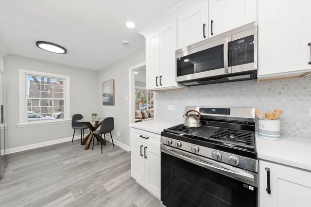 a kitchen with stainless steel appliances a stove a microwave and wooden cabinets