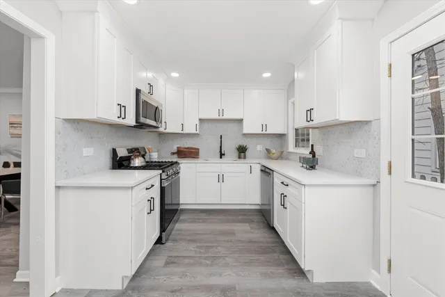 a kitchen with stainless steel appliances granite countertop a sink and a refrigerator