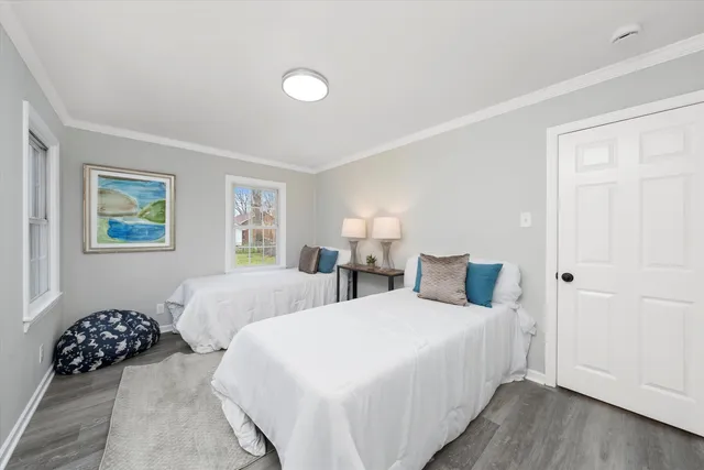 a bedroom with two beds and a potted plant