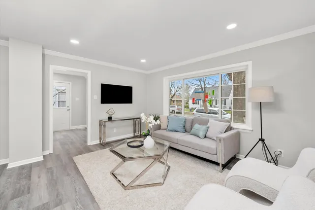 a living room with furniture a flat screen tv and a window