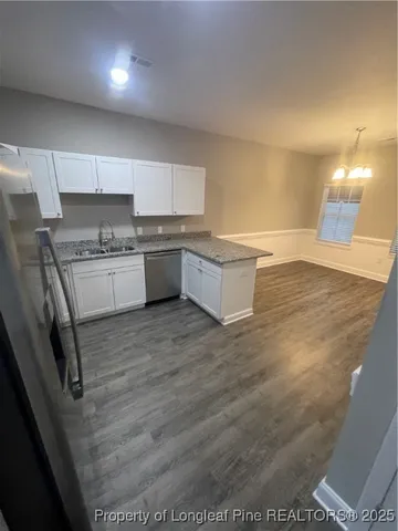 a kitchen with a sink cabinets and wooden floor