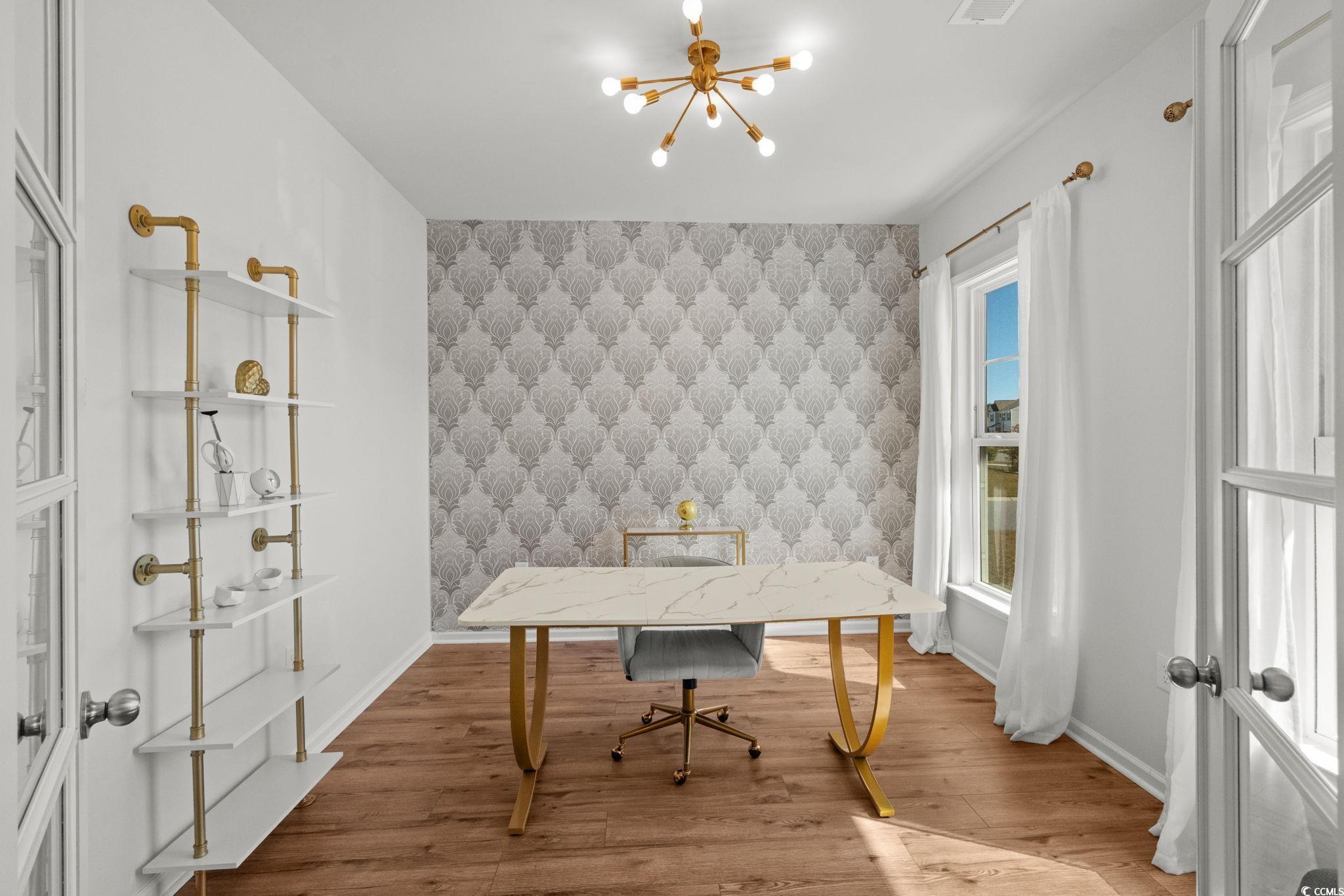 1663 Villena Drive Myrtle Beach, SC 29579 - Photo 13 of 40 Office area with a chandelier, wood finished floors, an accent wall, and wallpapered walls