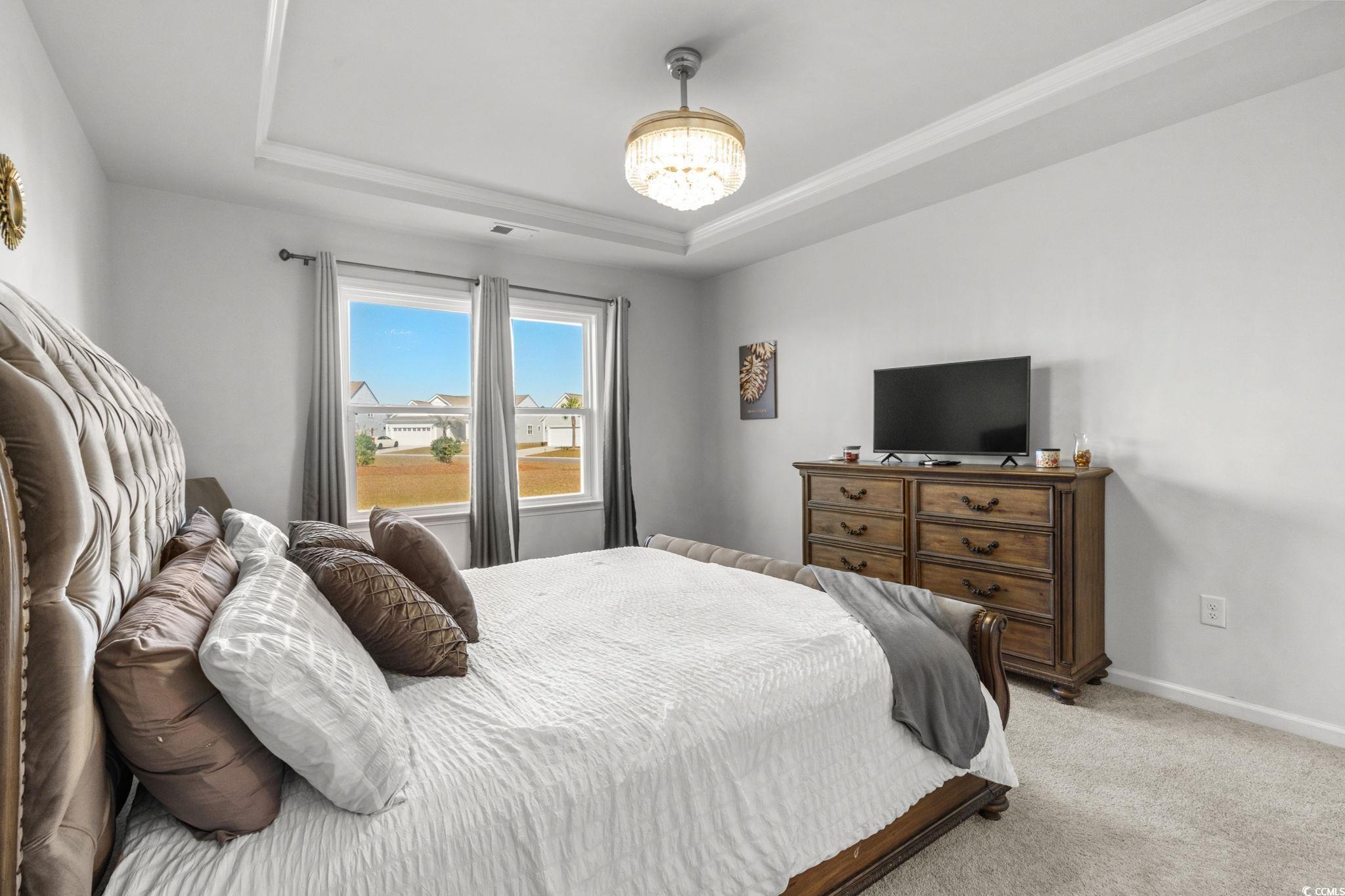 1663 Villena Drive Myrtle Beach, SC 29579 - Photo 16 of 40 Carpeted bedroom featuring a raised ceiling and a chandelier