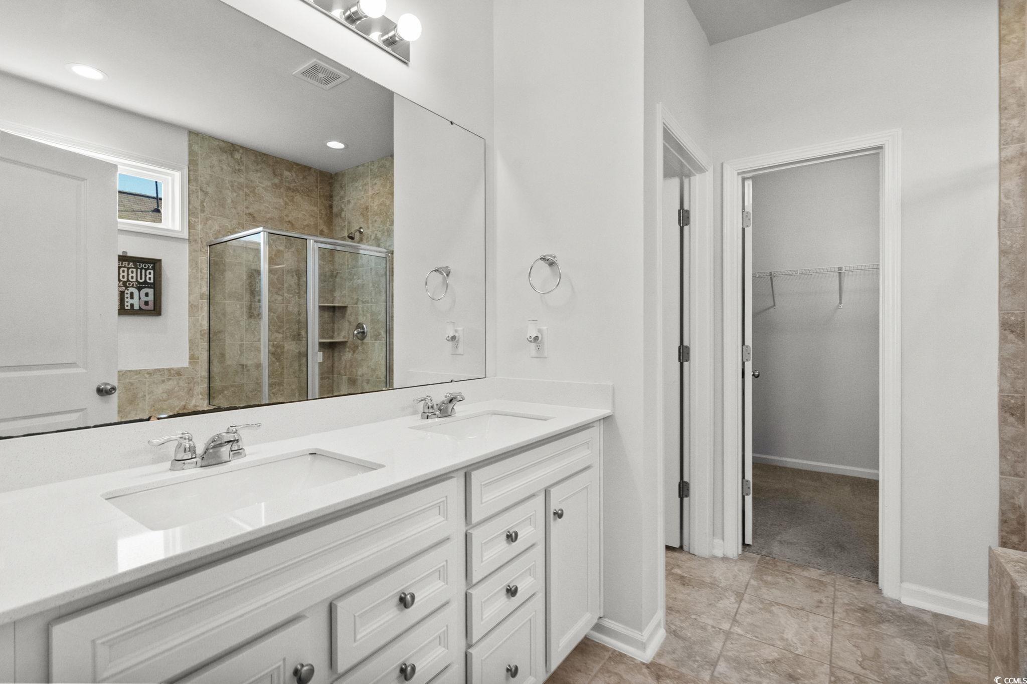 1663 Villena Drive Myrtle Beach, SC 29579 - Photo 18 of 40 Bathroom featuring a stall shower, a walk in closet, double vanity, and light tile patterned flooring