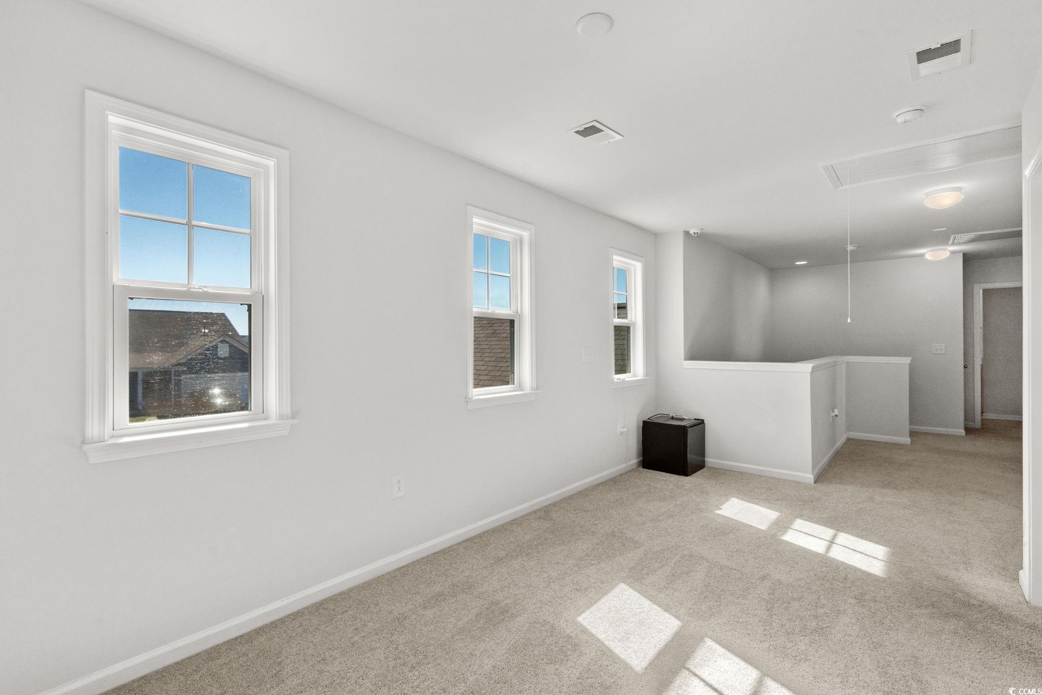 1663 Villena Drive Myrtle Beach, SC 29579 - Photo 23 of 40 Spare room with attic access, light carpet, and healthy amount of natural light