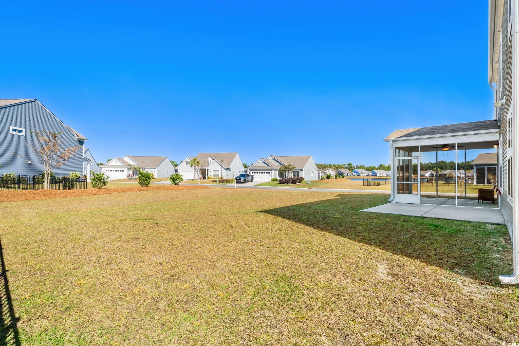 1663 Villena Drive Myrtle Beach, SC 29579 - Photo 32 of 40 View of grassy yard with a sunroom and ceiling fan