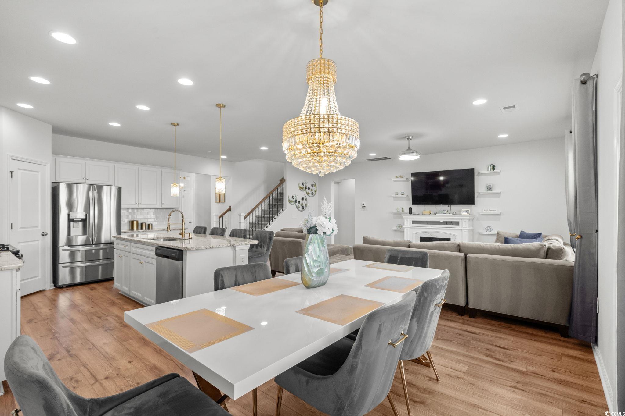 1663 Villena Drive Myrtle Beach, SC 29579 - Photo 7 of 40 Dining space featuring stairway, a chandelier, light wood-style floors, recessed lighting, and a fireplace