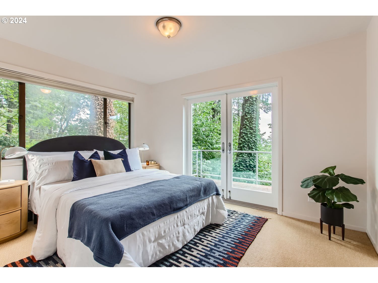 3831 Southwest Dosch Road Portland, OR 97239 - Photo 15 of 29 a bedroom with a bed lamp and a large window