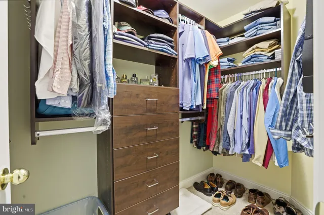a view of walk in closet with clothes and shoes