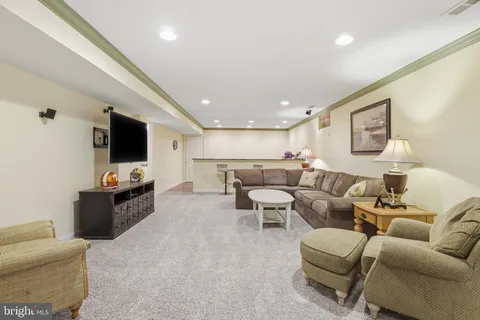 a living room with furniture pool table and a flat screen tv