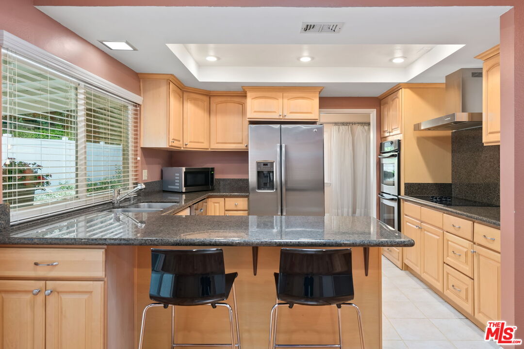 1463 Morrow Circle Thousand Oaks, CA 91362 - Photo 10 of 25 a kitchen with stainless steel appliances granite countertop a stove a sink and a microwave