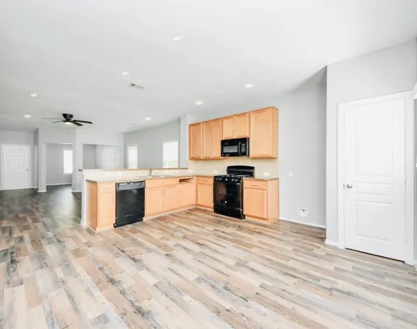 a view of kitchen with stove top oven and cabinets