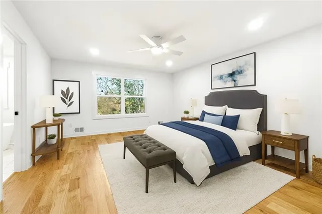 a spacious bedroom with a large bed and a chandelier