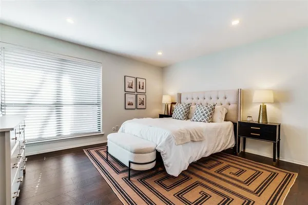 a spacious bedroom with a bed and wooden floor