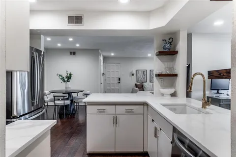a kitchen with a sink cabinets and wooden floor