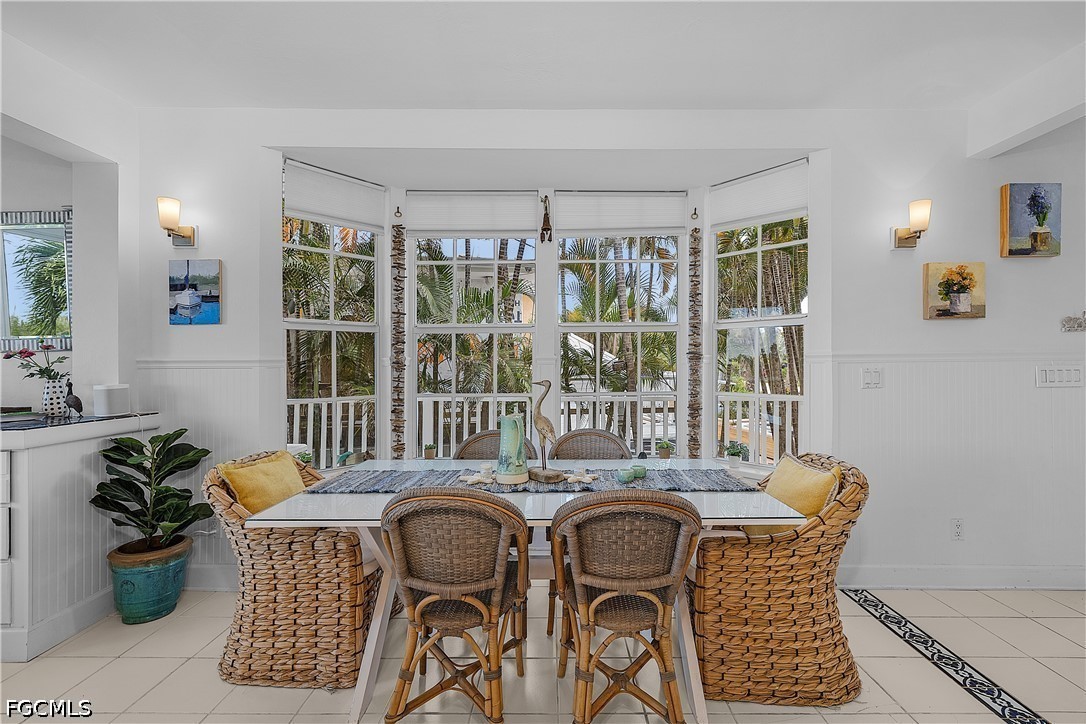 515 Useppa Useppa Island Bokeelia, FL 33922 - Photo 15 of 43 a dining room with furniture potted plants and wooden floor