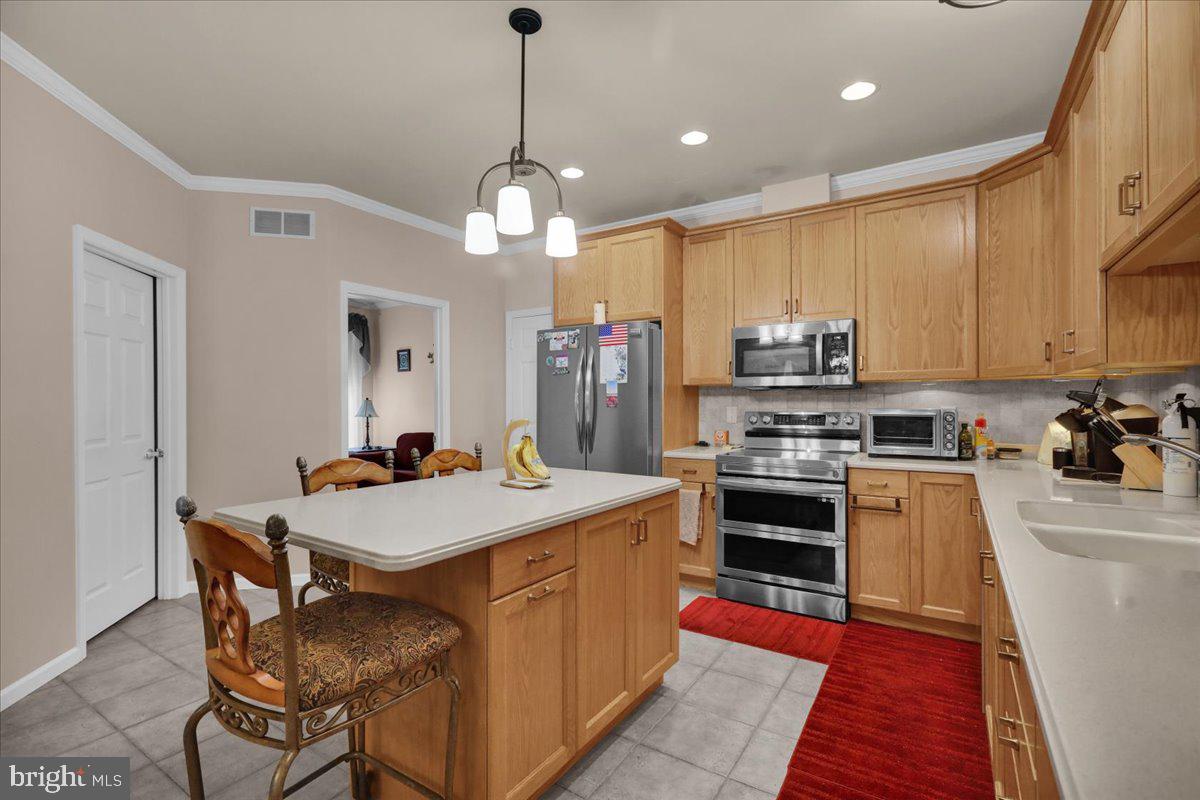 55 Turning Leaf Way Reading, PA 19605 - Photo 17 of 37 a large kitchen with stainless steel appliances granite countertop a stove oven a sink dishwasher and a dining table with chairs