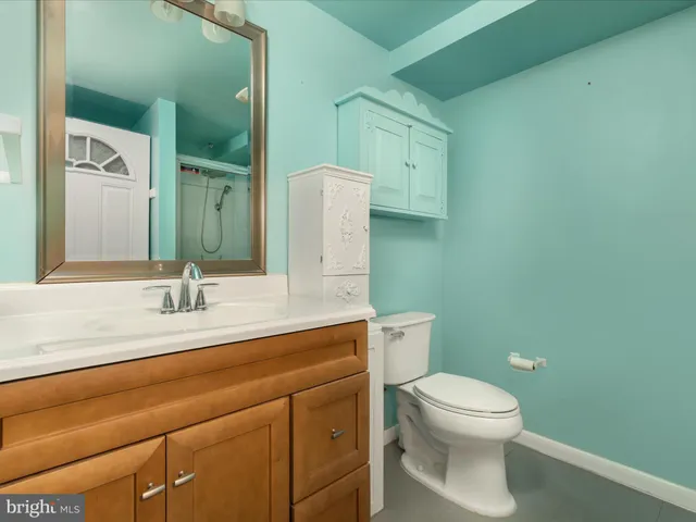 a bathroom with a toilet a sink and mirror